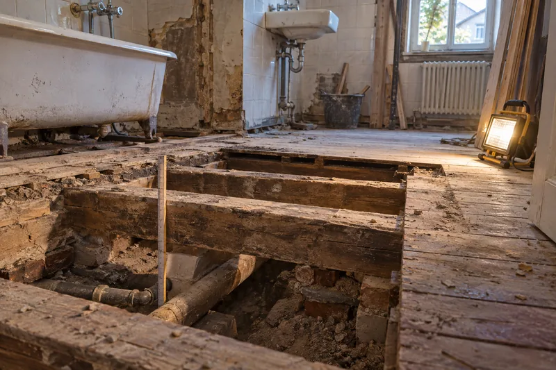 Badsanierung im Altbau: geöffneter Boden im Altbaubad mit Dielen und Holzbalkenlage